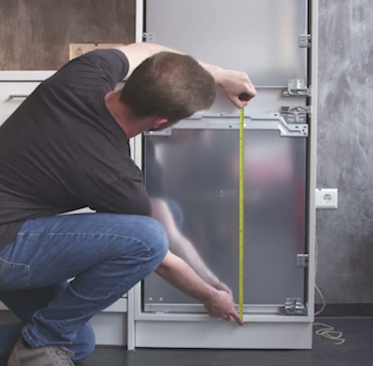 hombre instalando un frigorífico integrable.